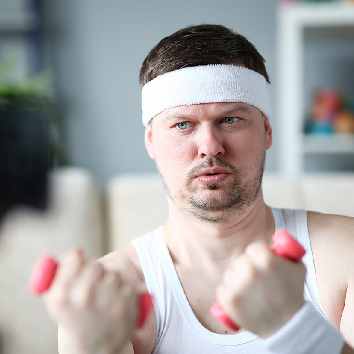 Harry Smith wearing a headband and lifting comically small pick weights